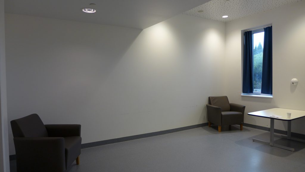 Rom med to stoler og hvite vegger