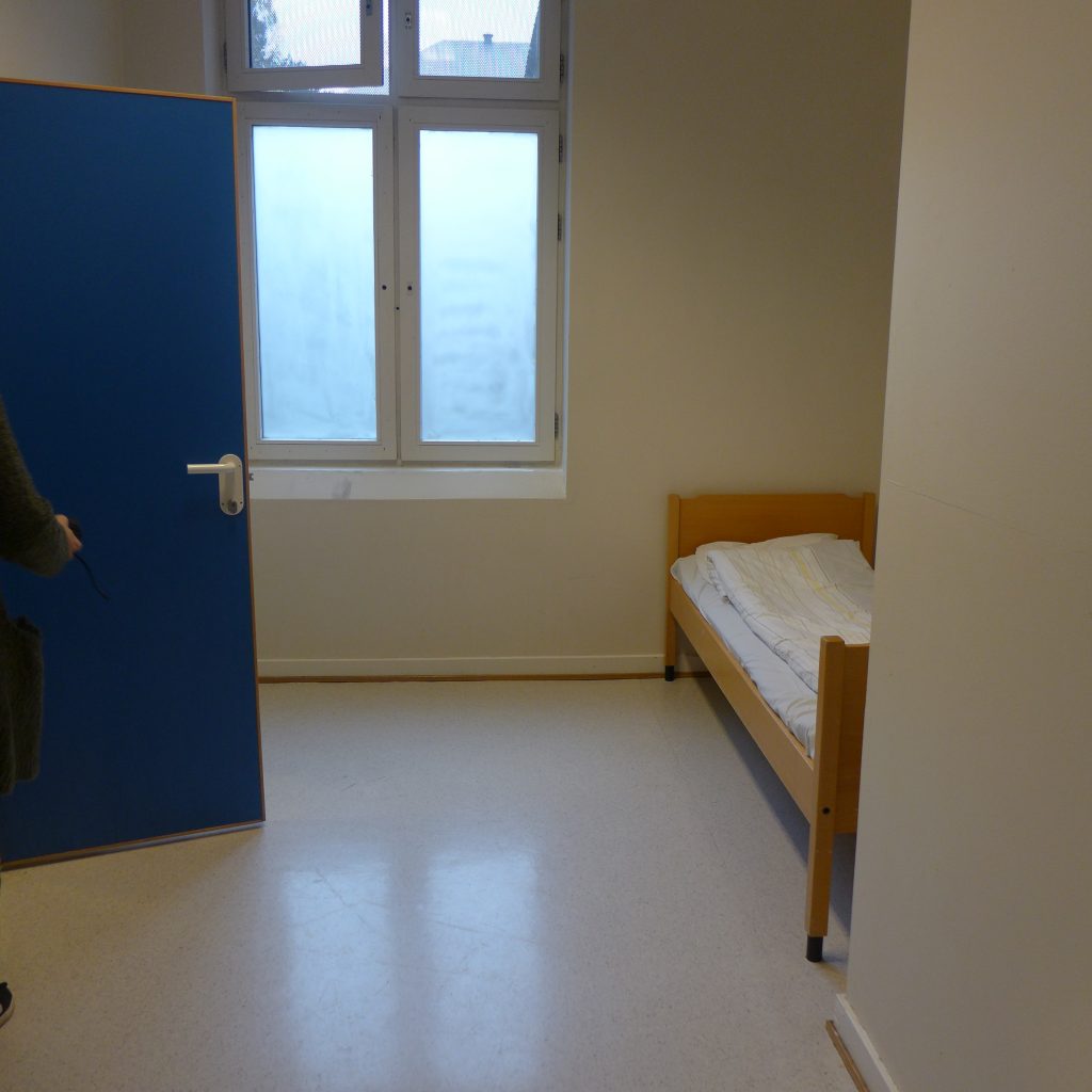 Åpen dør inn til et rom med seng