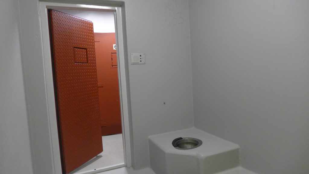 Celle med åpen dør og toalett i hjørnet