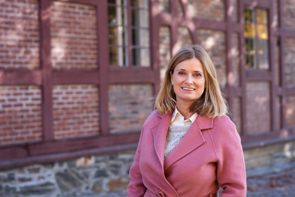 Sivilombud Hanne Harlem i rosa kåpe foran bygning på Akershus festning Foto: Mona Ødegård, Sivilombudet