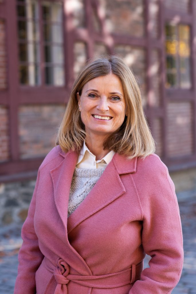 Sivilombud Hanne Harlem i rosa kåpe foran bygning på Akershus festning Foto: Mona Ødegård, Sivilombudet