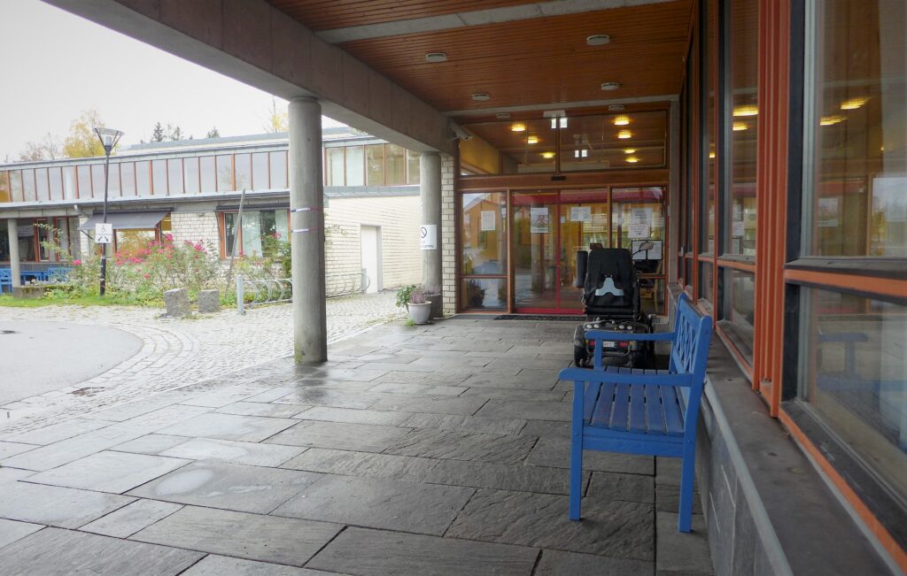 Uteområde sykehjem, steinplater og blå benk