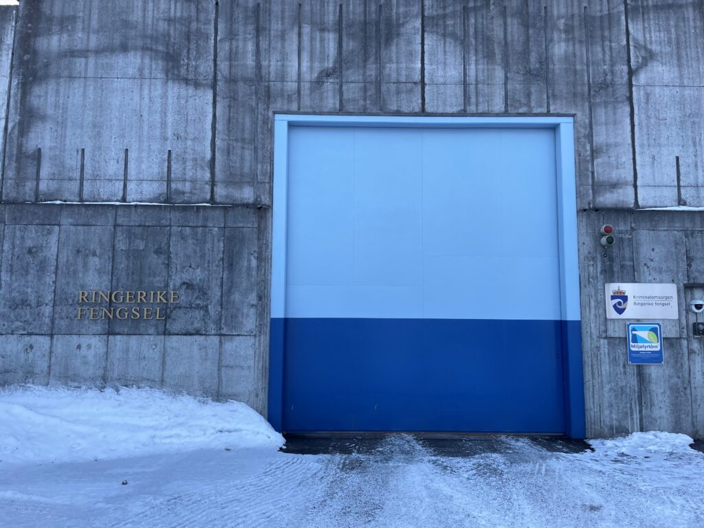 Grå murvegg med skilt 